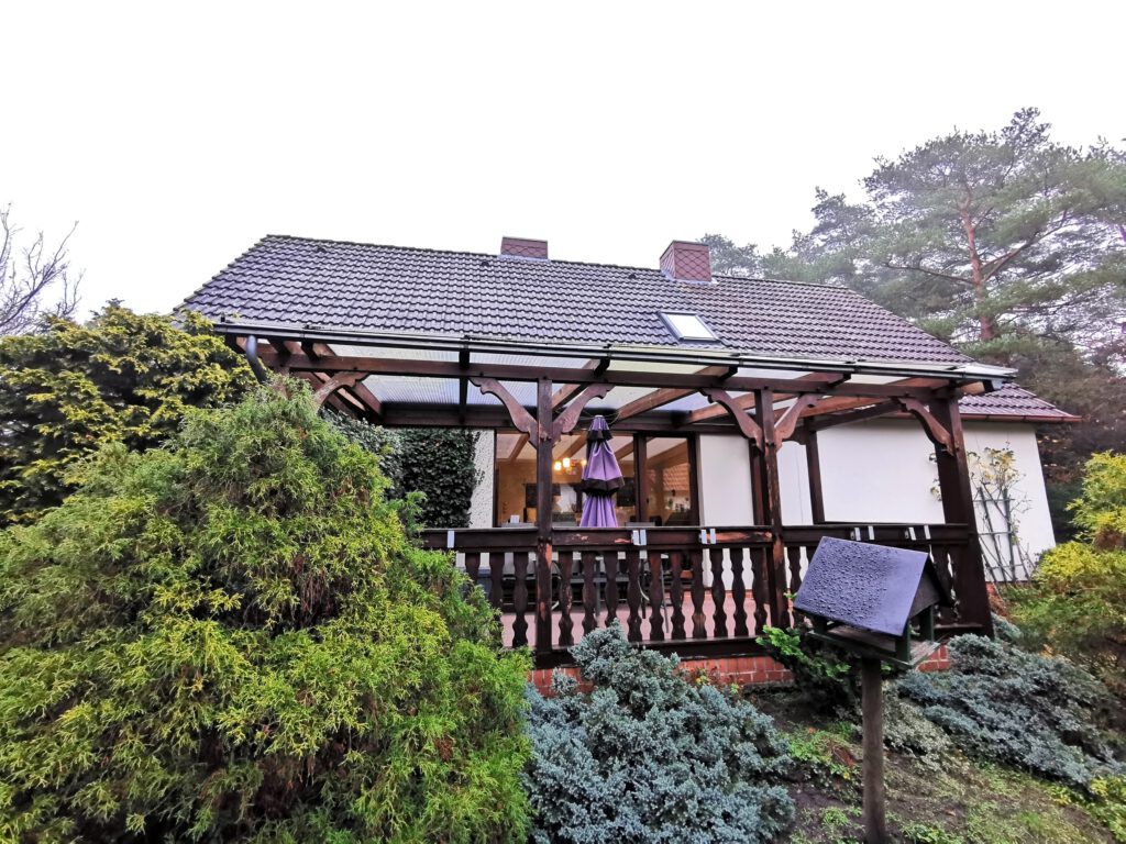 Rückansicht des Einfamilienhauses in Schneverdingen mit Loggia und Blick in den grünen Garten